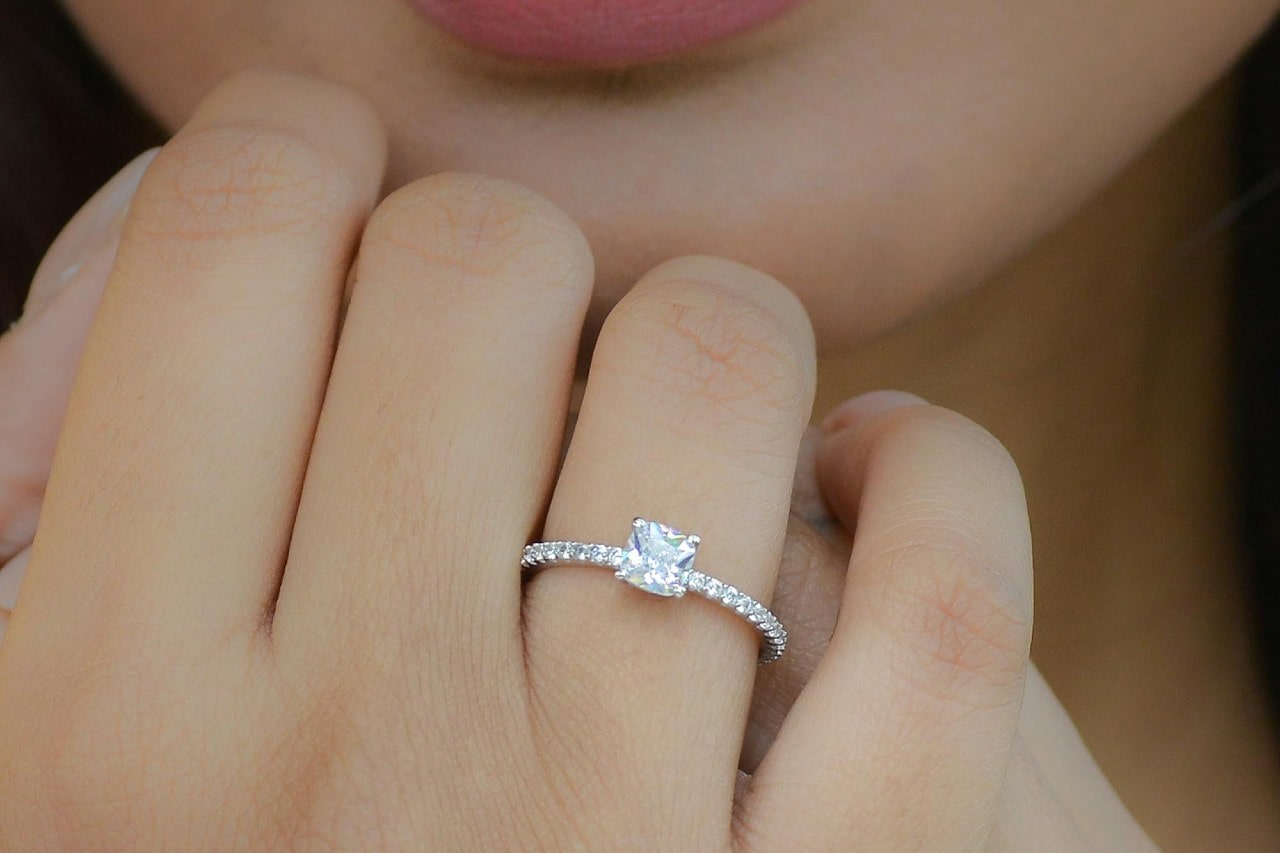 A close-up of a young woman’s stunning side stone engagement ring.