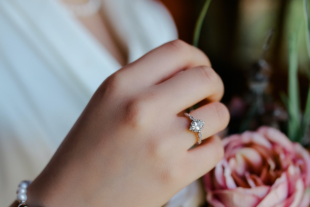 A close-up of a woman’s hand, emphasizing her elegant engagement ring.