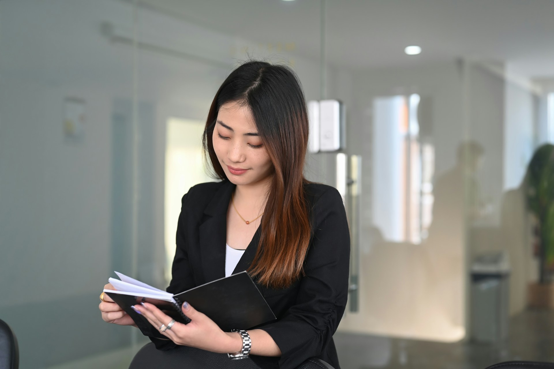 a lady holding a book and wearing a fine watch