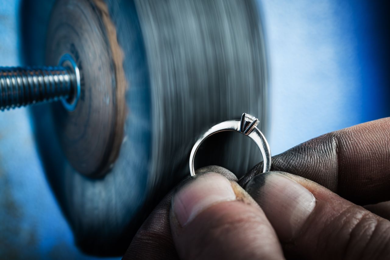 Goldsmith polishing an engagement ring.