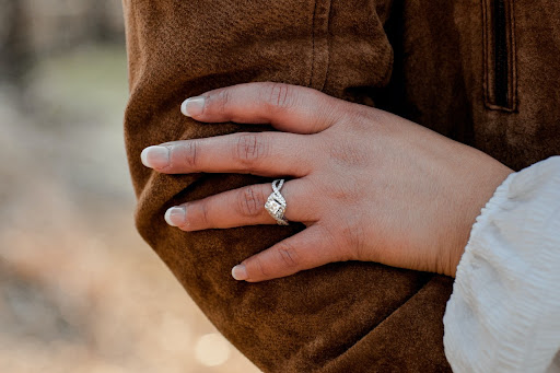 woman holding man arm with ring