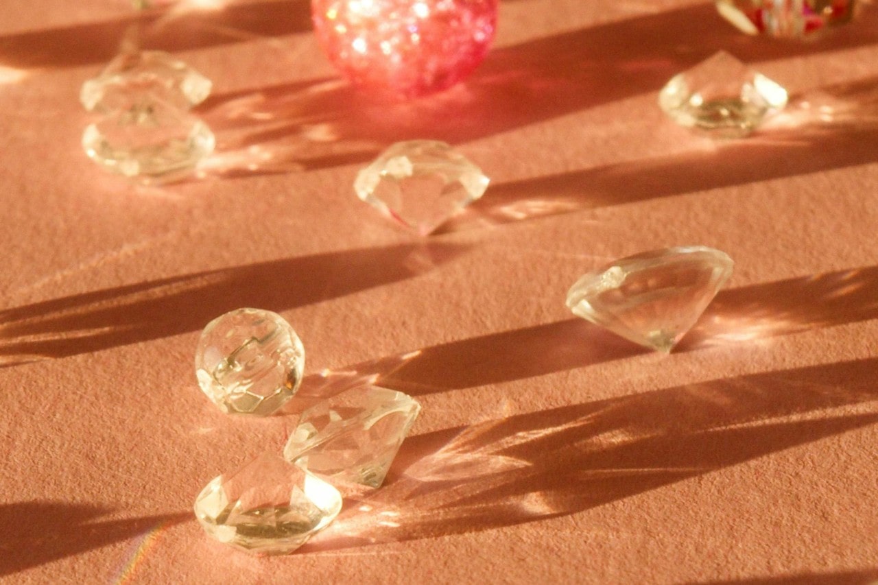 round cut diamonds sitting on an orange surface in the light