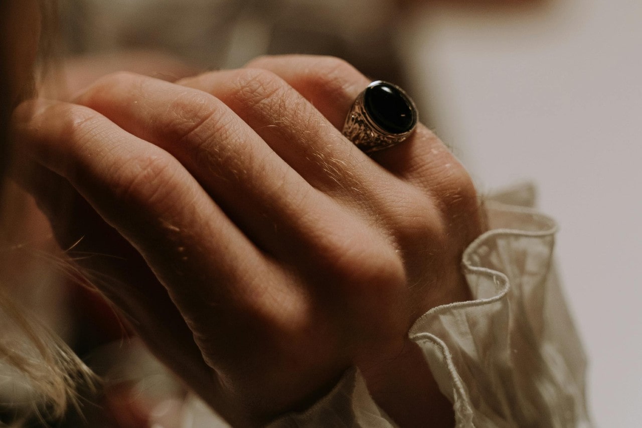 a woman’s hand adorned with a silver and black onyx ring