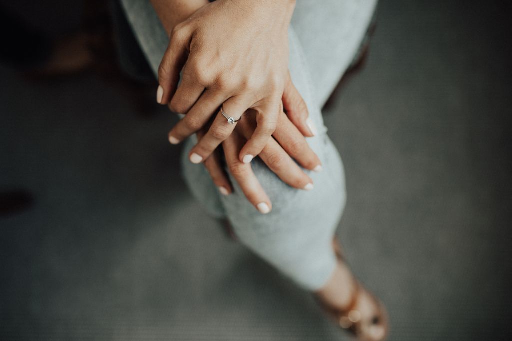 pear shape ring on two hands on knee