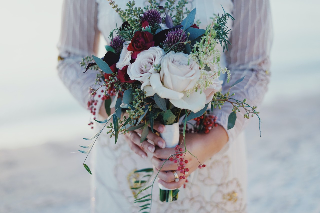 woman holding flowers with engagement ring